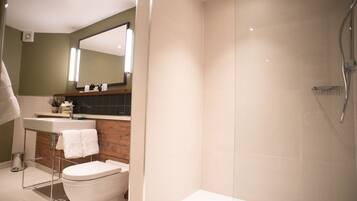 Ein modernes Badezimmer mit Toilette, Waschbecken und Dusche.