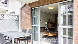 A modern apartment with a dining area, a sofa, and a small table. - Carolin Dangast (Varel)