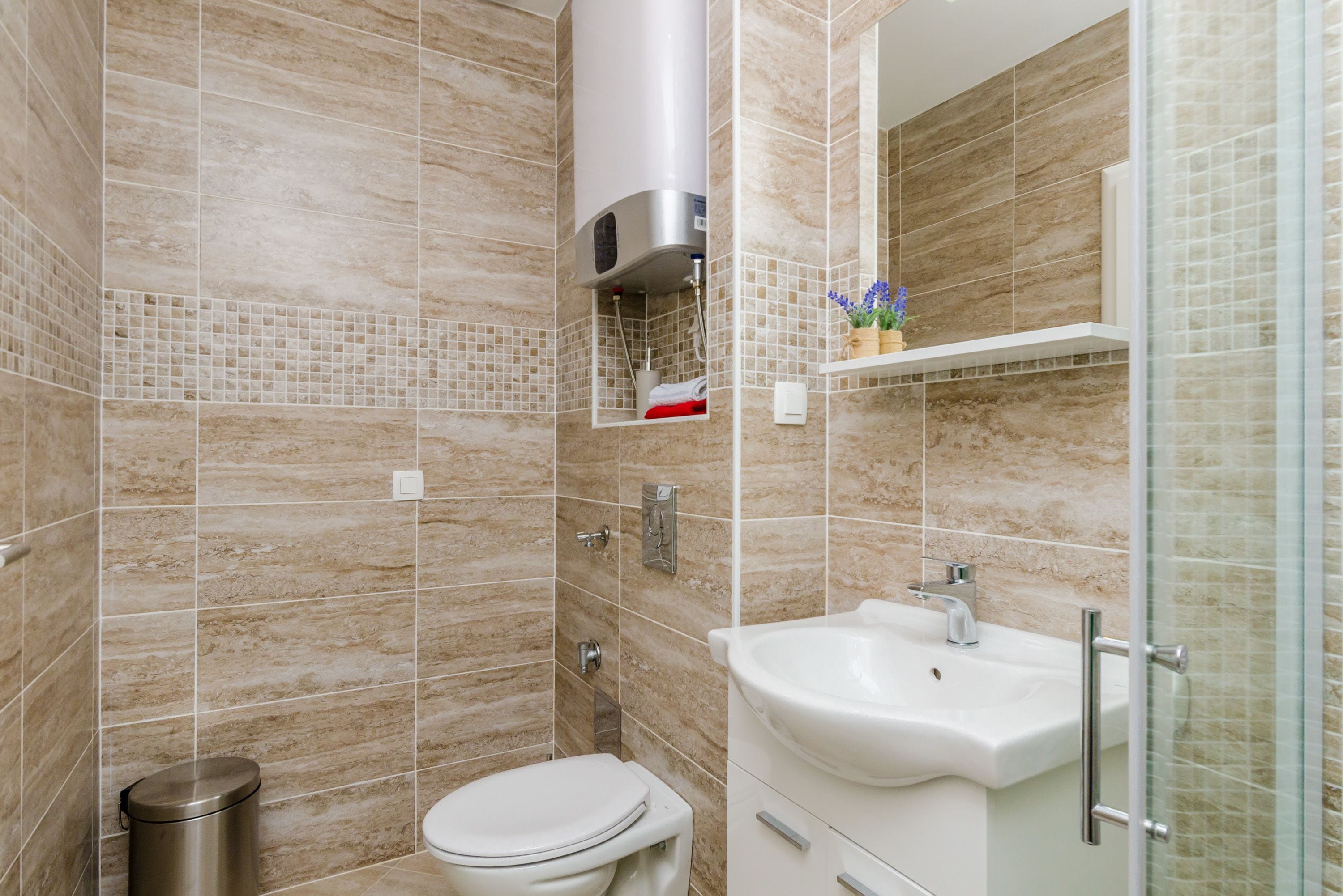 A modern bathroom with a toilet, sink, and shower.