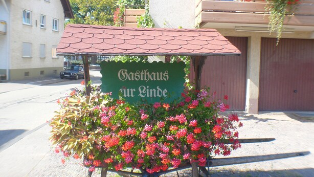 A cart with a sign reading "Gasthaus zur Linde" surrounded by flowers. - Gasthaus Metzgerei Zur Linde (Kenzingen)