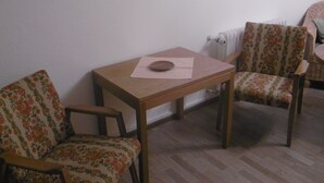 A room with a wooden table and two floral-patterned chairs. - Gasthaus Metzgerei Zur Linde (Kenzingen)