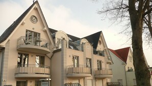 A multi-story building with balconies, a clock, and a sign indicating a restaurant. - Antonia Rerik (Rerik)