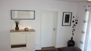 Un salon moderne avec un canapé, un meuble blanc et une porte.