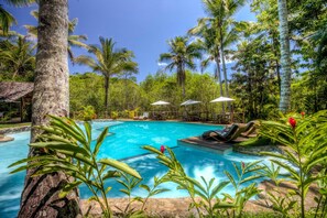 A swimming pool surrounded by palm trees and lounge chairs. - Itacaré Eco Resort (Itacaré)