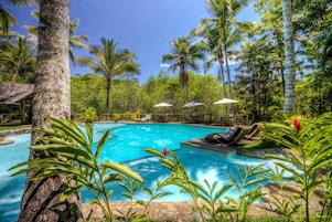 Una piscina al aire libre, tumbonas