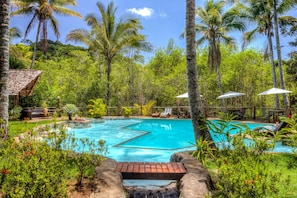 Una piscina al aire libre, sillones reclinables de piscina