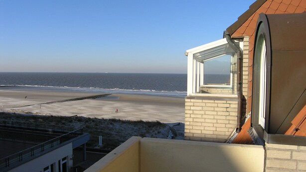 Vista de una playa desde un edificio con ventana con vista al océano.