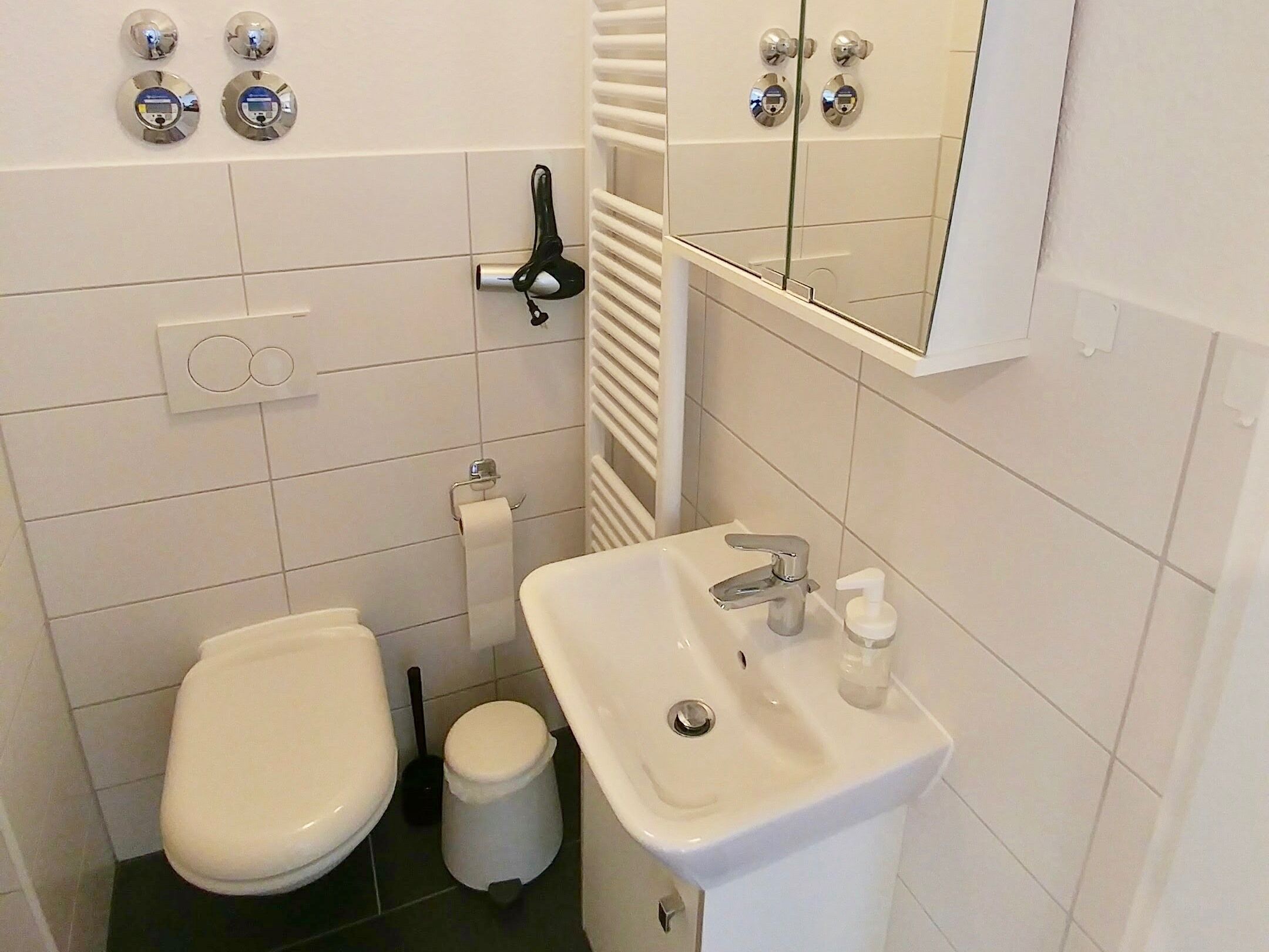 A small, compact bathroom with a toilet, bidet, and sink.