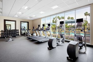 A gym with treadmills, elliptical machines, and dumbbells. - Hampton Inn & Suites San Diego Airport Liberty Station (San Diego)