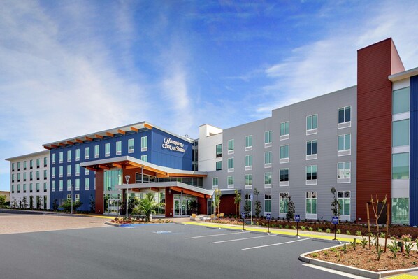 A modern hotel with a prominent entrance, multiple floors, and a parking lot. - Hampton Inn & Suites San Diego Airport Liberty Station (San Diego)