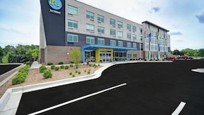A modern hotel building with a prominent 'tru by Hilton' sign, a covered entrance, and a parking lot. - Tru by Hilton Grand Rapids Airport (Grand Rapids)