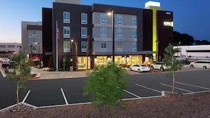 Een meerhoog hotel met een modern ontwerp, met een opvallend 'HOME2'-bord op de gevel.