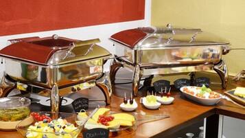 Disposição de buffet com diversos alimentos e estações de serviço.