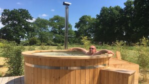 A wooden hot tub on a deck with a metal heater above it. - Ecolodges de Loire & Spa (Gennes-Val-de-Loire)