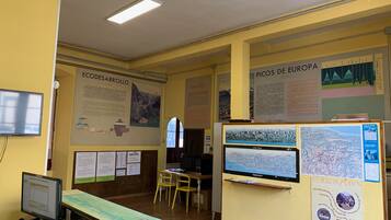A room with a computer, a desk, chairs, and informational posters on the walls.