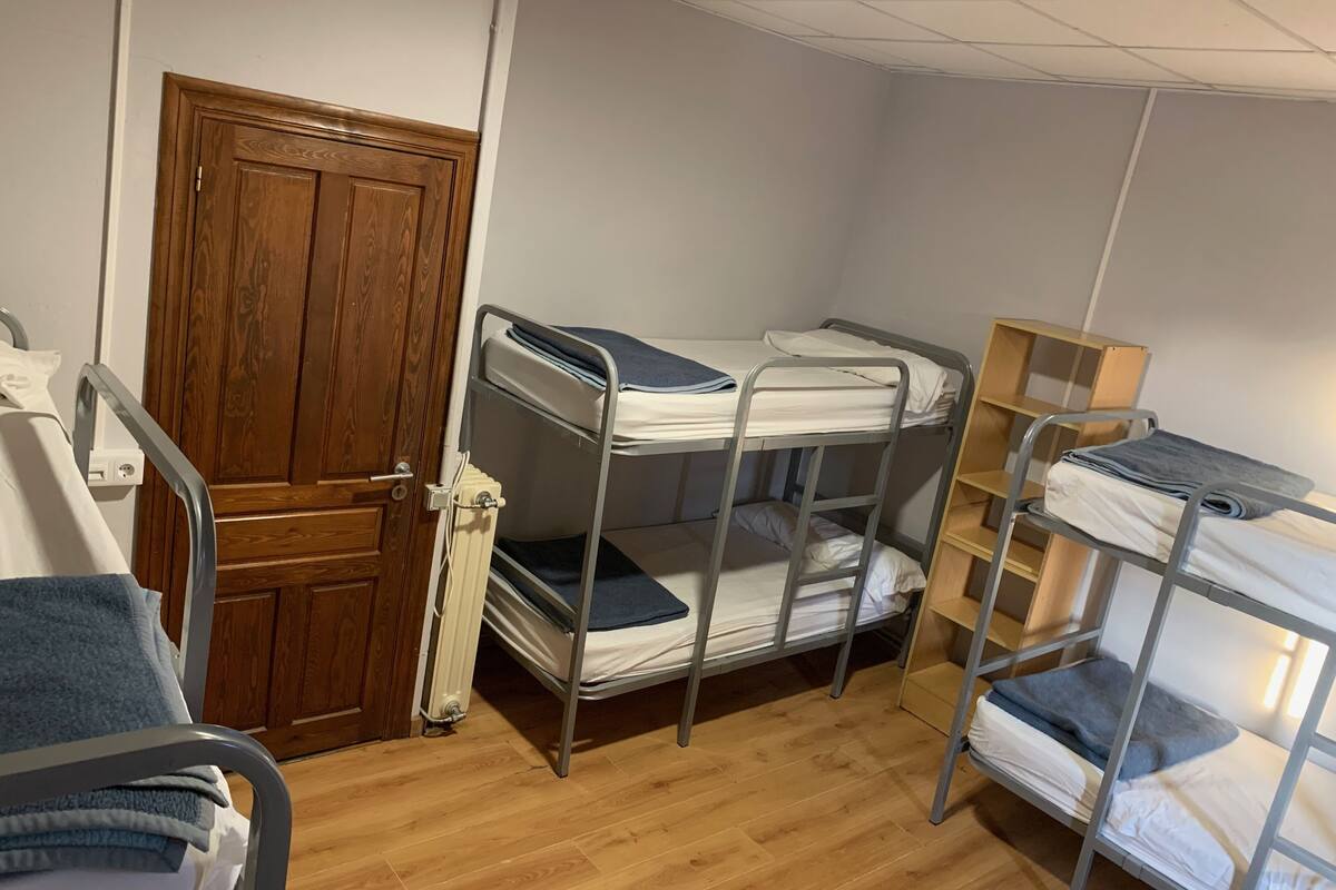 A room with bunk beds, a wooden door, and a radiator.