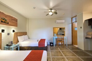 A hotel room with two beds, a desk, a chair, a ceiling fan, an air conditioning unit, and a small trash bin. - Casa Andina Standard Ica   (Ica)