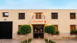 Un edificio con un letrero que dice 'CASA ANDINA STANDARD' y un portón negro con la leyenda 'SALIDA'.