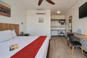 A hotel room with a bed, a desk, a chair, a TV, and an air conditioning unit. - Casa Andina Standard Ica   (Ica)