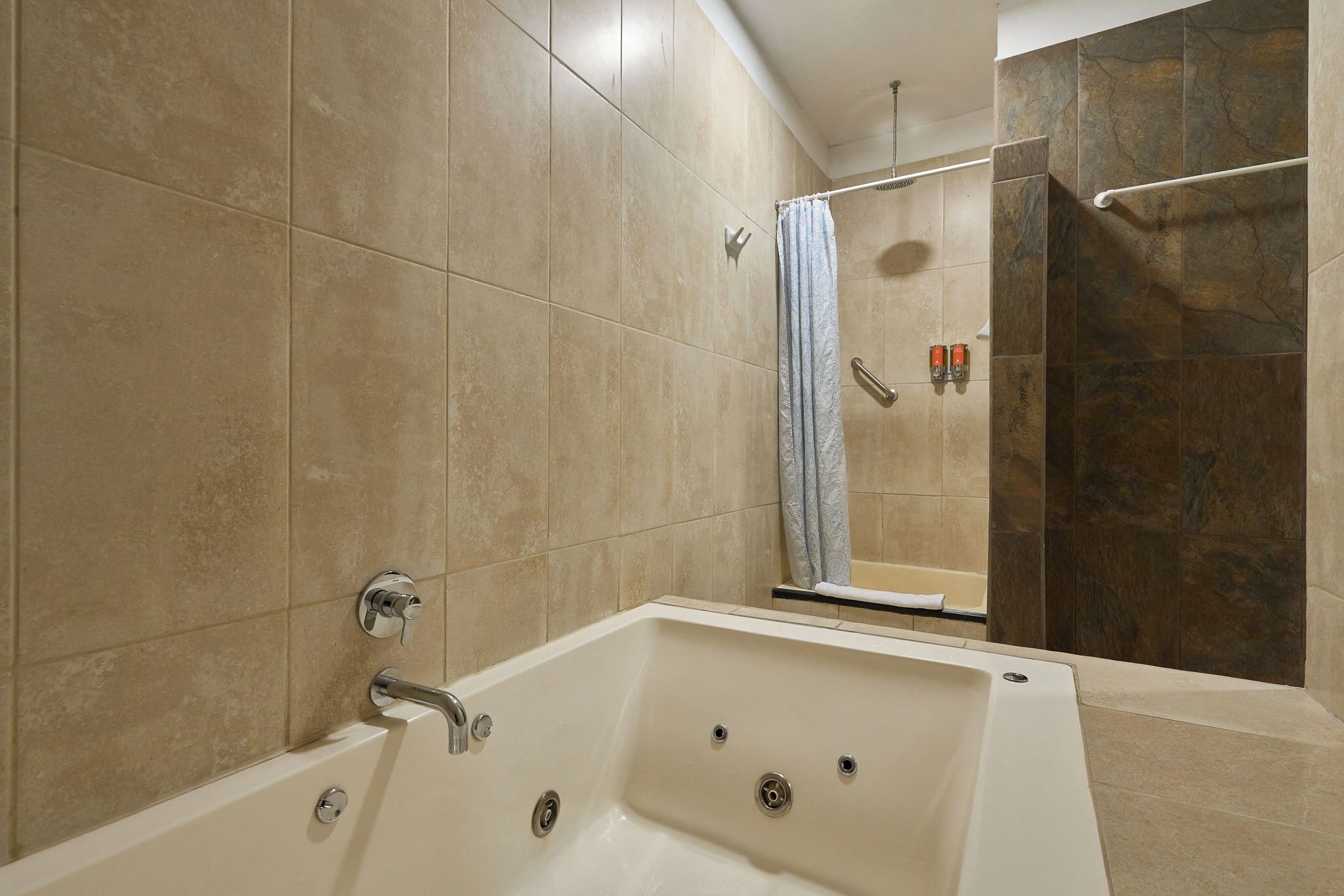 Un baño moderno con una bañera grande, una zona de ducha y un inodoro.