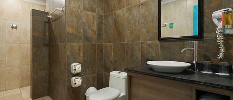 Un baño moderno con ducha, inodoro, lavabo y un espejo sobre el lavabo.