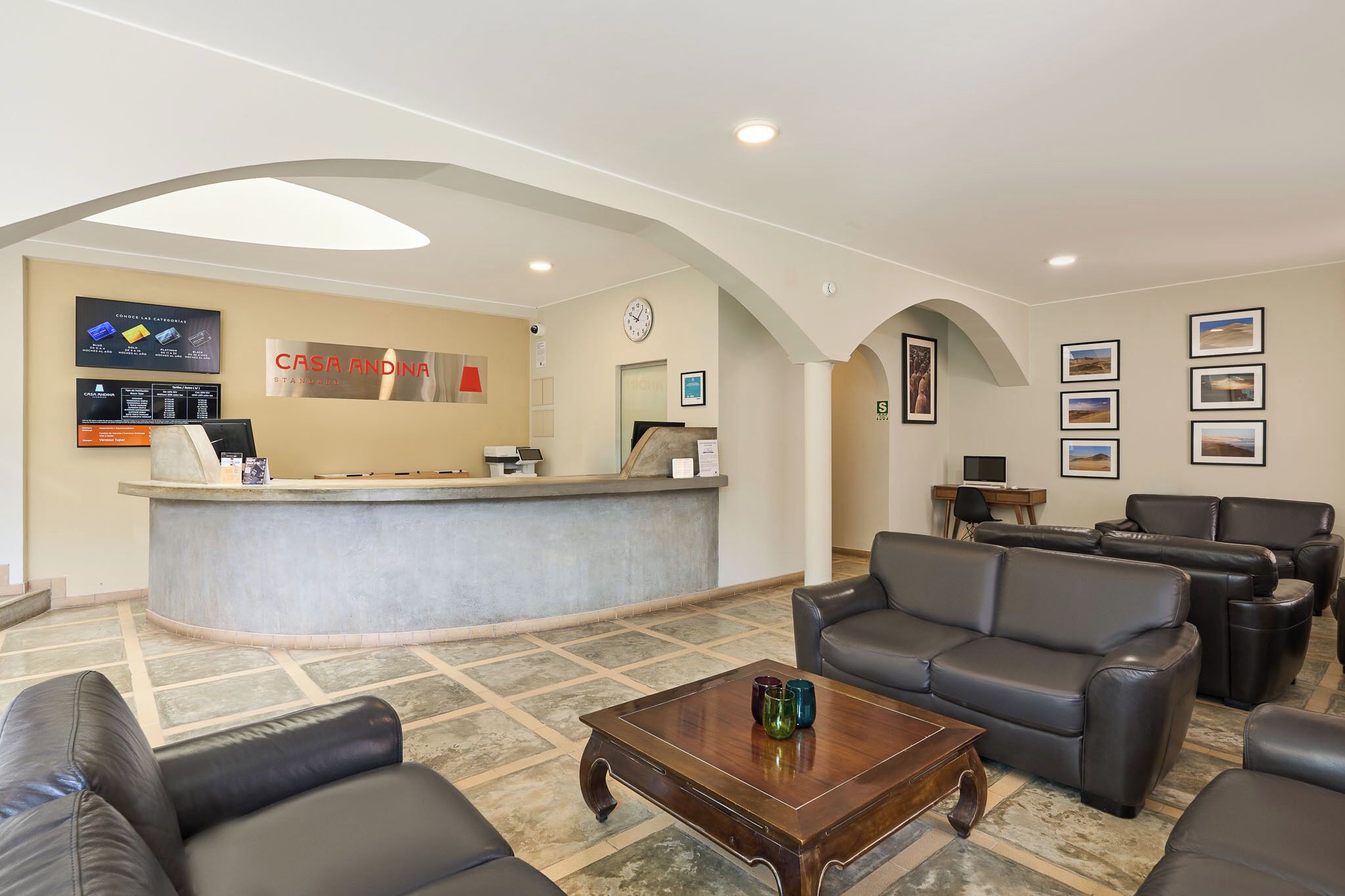 Ett receptionsområde med en disk, sittplatser och en klocka.