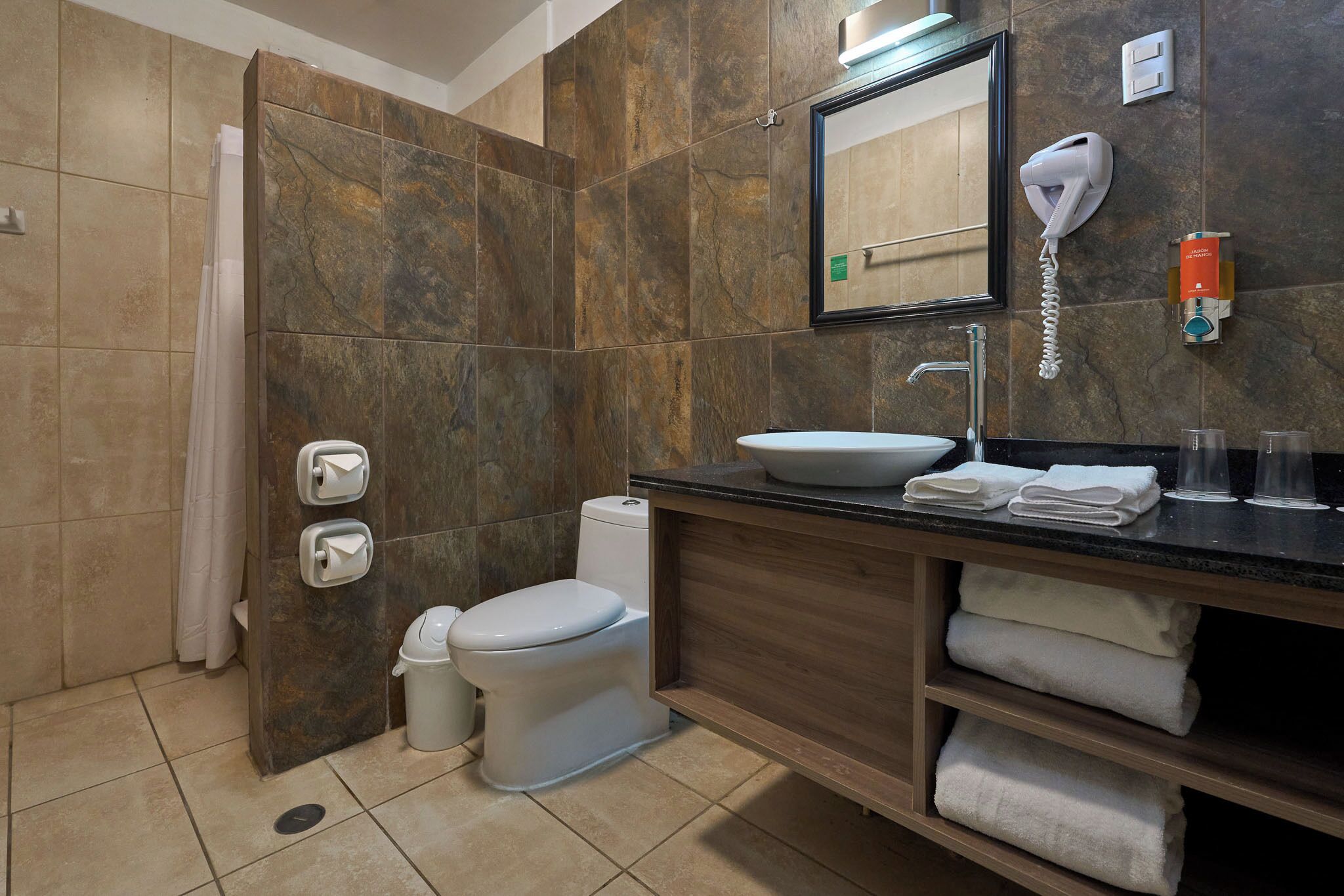 A modern bathroom with a toilet, sink, and shower.