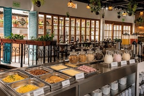 A buffet area with various food options, a coffee station, and a sign indicating an emergency exit.