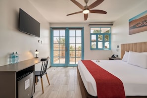 A hotel room with a bed, desk, chair, and a ceiling fan. - Casa Andina Standard Ica   (Ica)