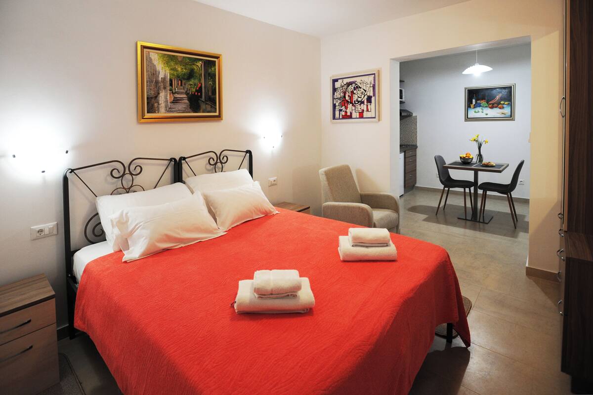 Une chambre d’hôtel avec un lit, une chaise, une table et des œuvres d’art accrochées aux murs.