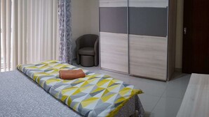 A bedroom with a bed, a chair, and a wardrobe. - Flat in Gzira 2 minutes from the sea (Gzira)