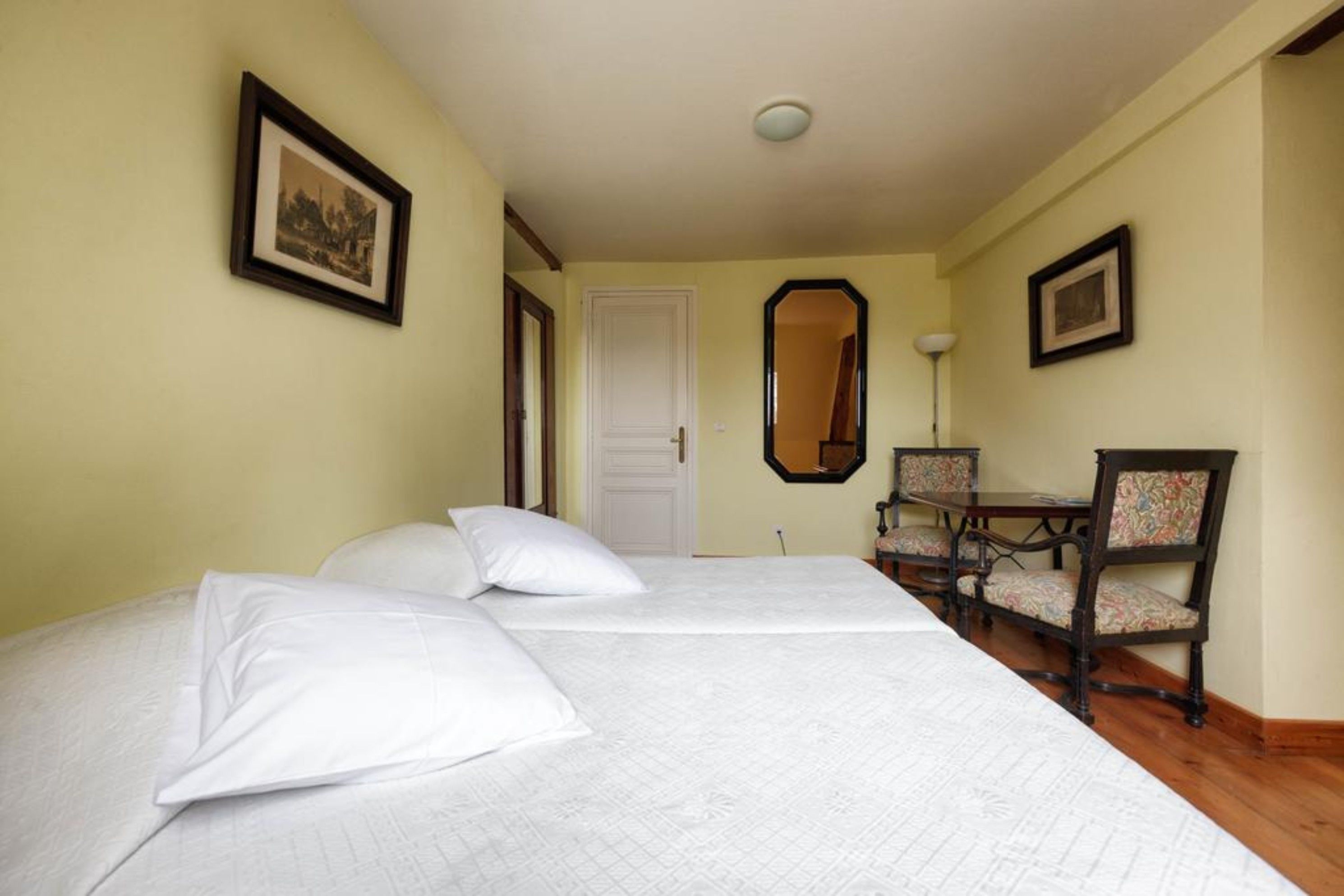 Una habitación de hotel con una cama, un escritorio y dos sillas.