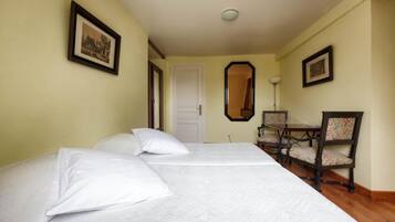 Una habitación de hotel con una cama, un escritorio y dos sillas.