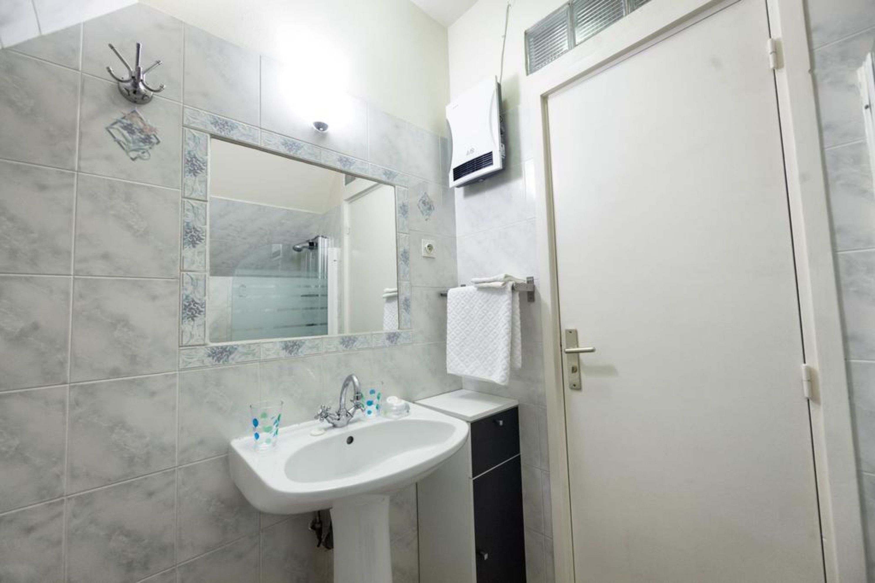 Ein Badezimmer mit Waschbecken, Spiegel und Handtuchhalter.