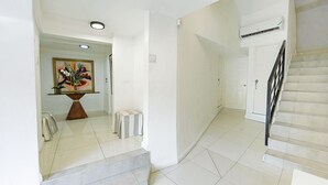 Un interior limpio y moderno con una escalera, una puerta blanca y un cuadro en la pared.