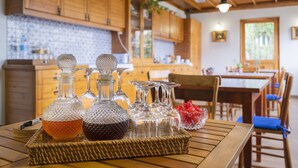 Eine Küche mit Holzausstattung, gefliestem Rücksprung und einem Essbereich mit Tisch und Stühlen.