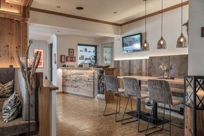 A modern bar area with a stone counter, bar stools, and pendant lighting. - Aktivhotel Gasteiner Einkehr (Dorfgastein)
