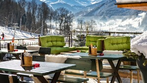 A snow-covered mountain view with outdoor seating and tables. - Aktivhotel Gasteiner Einkehr (Dorfgastein)
