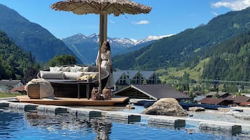 Una piscina al aire libre, sombrillas, tumbonas