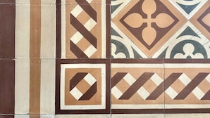 A section of a tiled wall with geometric patterns and floral motifs. - Lucca Charm (Lucca)