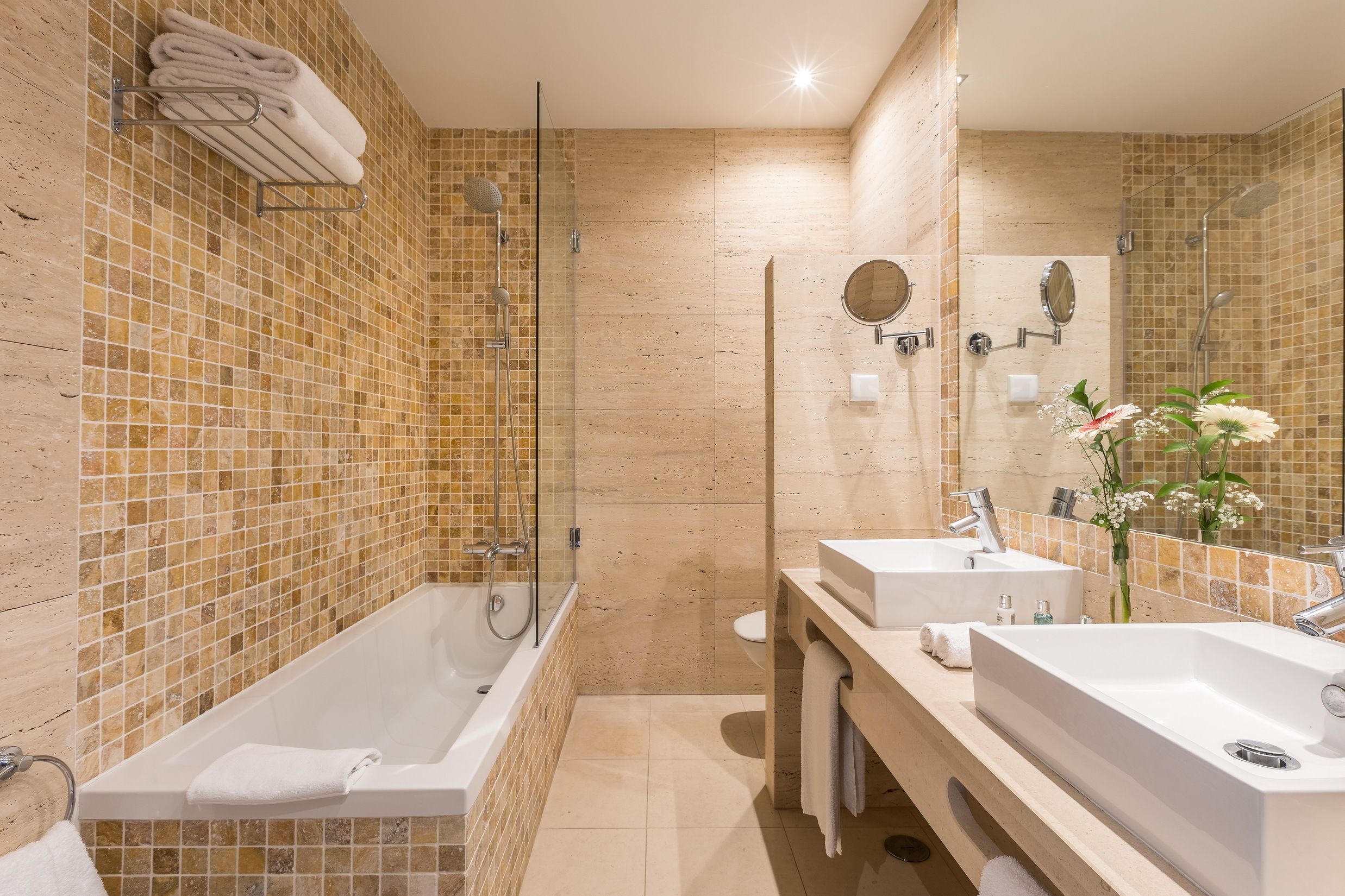 A modern bathroom with a glass-enclosed shower, two sinks, and a large mirror.