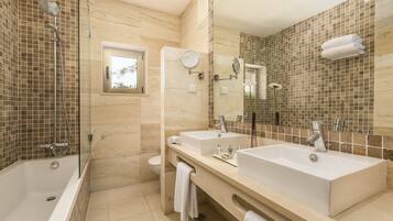Un baño moderno con una bañera grande, dos lavamanos, una ducha y un ventanal.