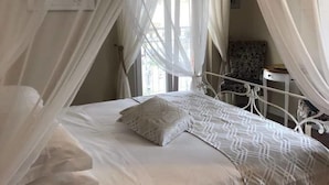A bed with a canopy, a patterned bedspread, and a pillow. - B&B Baronia Luxury Rooms (Castel Baronia)