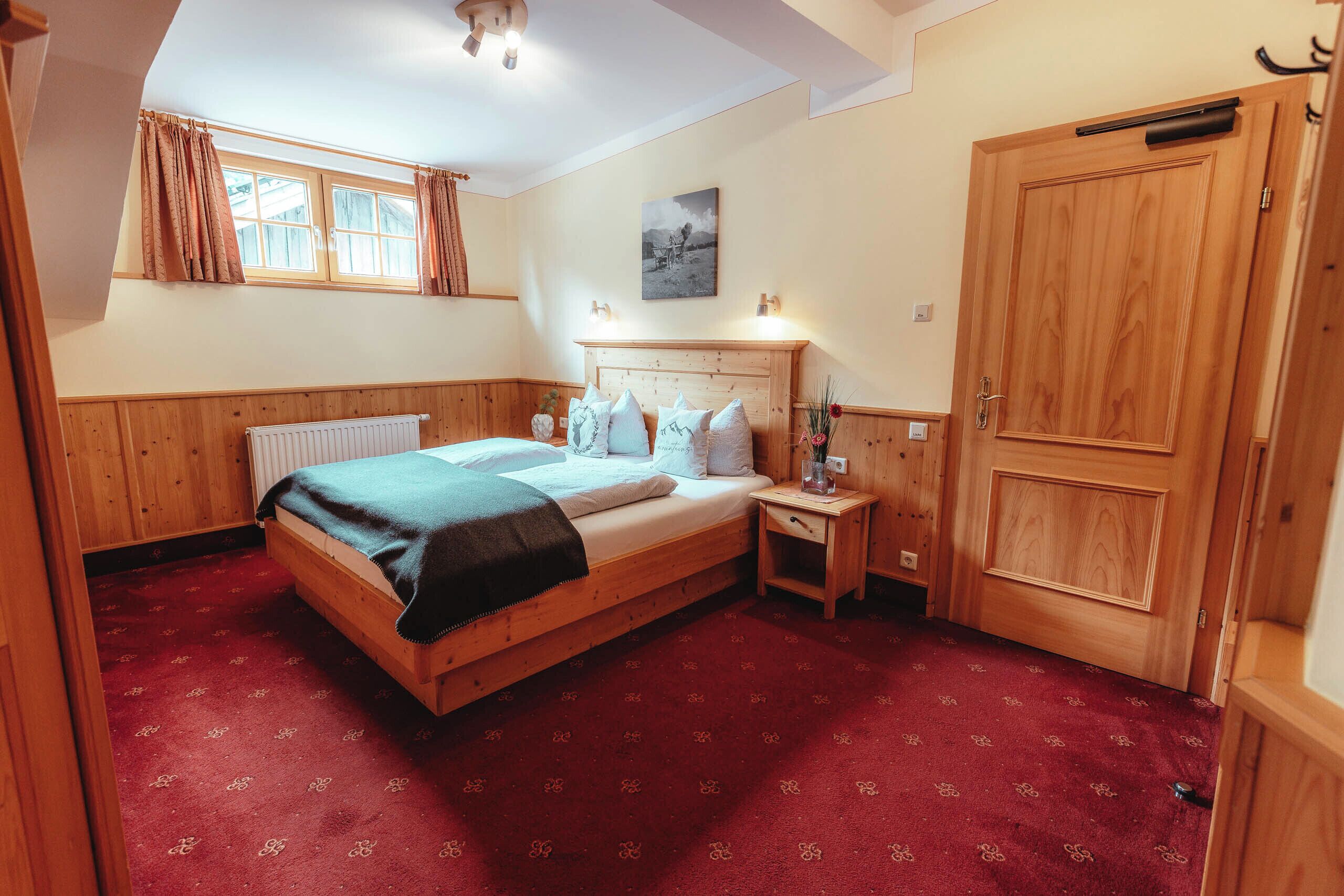 Une chambre à coucher avec un lit en bois, une table de chevet, un radiateur et une armoire.