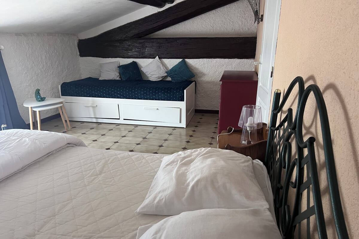 A bedroom with a bed, a small table, a wardrobe, and a lamp.