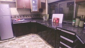 Una cocina con armarios oscuros, encimera de granito y ventana con vista a la ciudad.