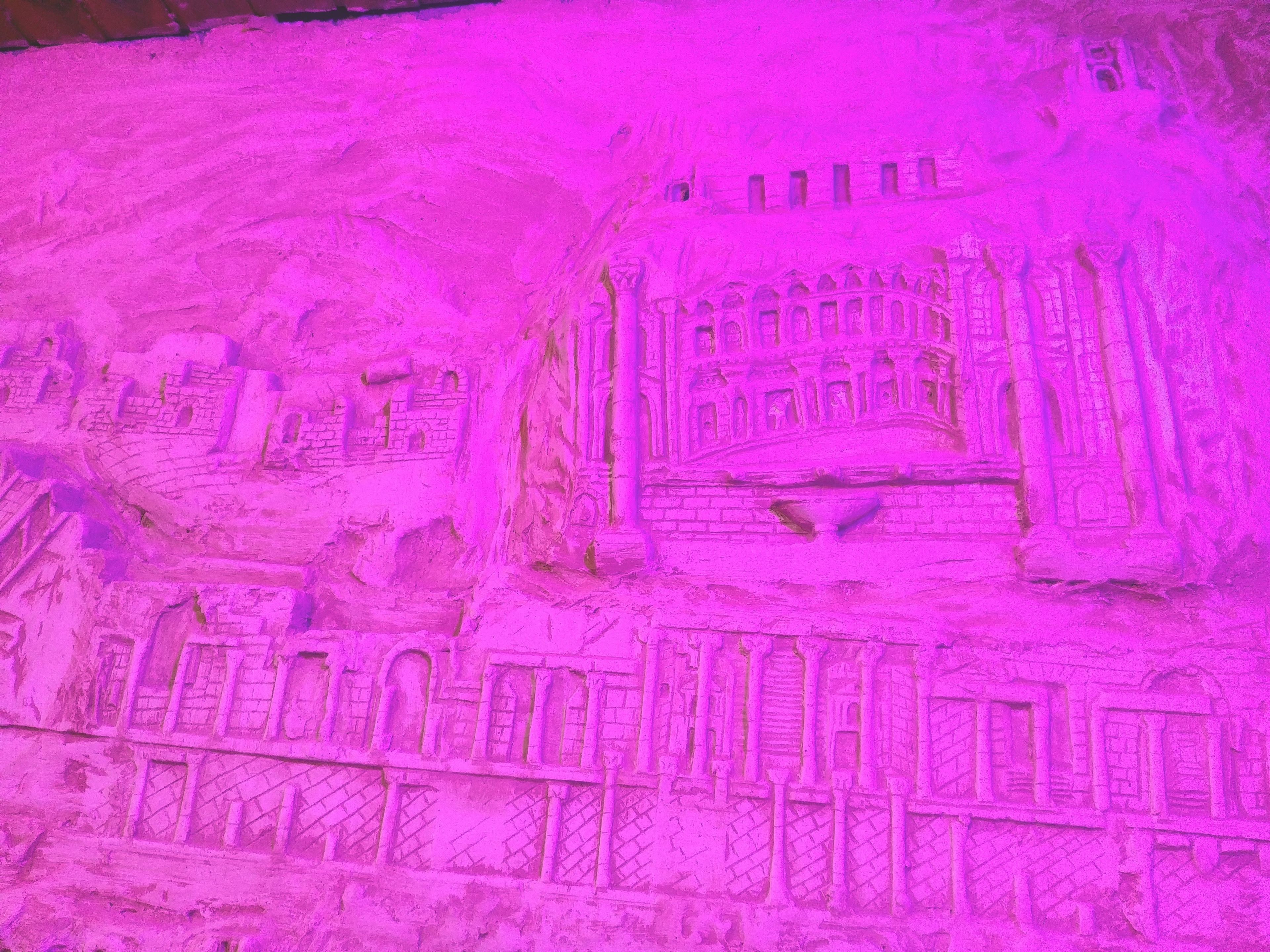 A detailed architectural carving of a building with multiple arches and columns.