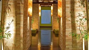 A corridor with brick walls, wooden beams, and potted plants. - Bella Ilha Pousada (Ilhabela)