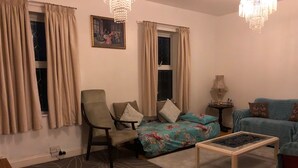 A cozy living room with a sofa, armchair, and coffee table. - 2 Bed Apartment in Basingstoke (Basingstoke)