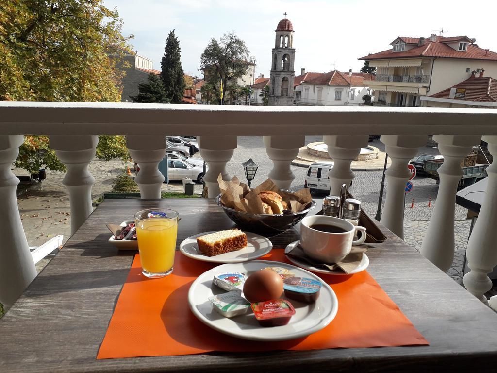 A breakfast table with orange placemats, a glass of orange juice, a cup of coffee, a plate with a croissant, a plate with a chocolate bar, and a plate with a chocolate bar.